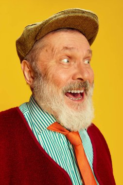 Klasik kıyafetler, gözlükler ve parlak sarı arka planda poz veren son sınıf öğrencisinin portresi. Mutlu, pozitif, heyecanlı. Duyguların kavramı, yüz ifadesi, yaşam tarzı, modern moda.