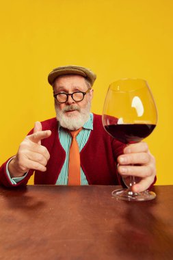 Klasik elbiseli, gözlüklü, kırmızı şarap kadehiyle poz veren son sınıf öğrencisinin portresi. Tat. Duyguların kavramı, yüz ifadesi, yaşam tarzı, modern moda.