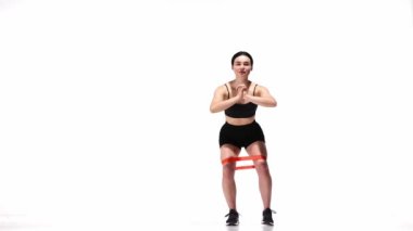 Beyaz stüdyo geçmişinde fitness elastik bantlı genç kız eğitimi. Bacak egzersizleri. Modern spor, aksiyon, hareket, gençlik konsepti. Fitness, hobi, sağlıklı yaşam tarzı