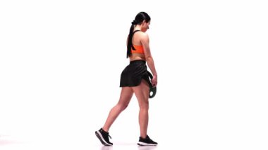 Spor malzemeleriyle antrenman yapan genç bir kız, ağırlıklar beyaz stüdyo geçmişi üzerinde. Romen itme egzersizi. Modern spor, aksiyon, hareket, gençlik konsepti. Fitness, hobi, sağlıklı yaşam tarzı