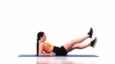 Genç, sportif bir kız, beyaz stüdyo arka planında yatıp antrenman yapıyor. Makas egzersizleri. Modern spor, aksiyon, hareket, gençlik konsepti. Fitness, hobi, sağlıklı yaşam tarzı