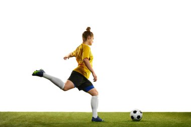 Kazanan gol. Genç profesyonel bayan futbolcu hareket halinde, antrenman yapıyor, futbol oynuyor, beyaz arka planda izole edilmiş futbol oynuyor. Spor, eylem, hareket, hedefler, rekabet, hobi, reklam kavramı.