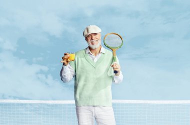 Beyaz takım elbiseli yakışıklı bir adamın portresi. Tenis raketi ve mavi arka planda taze meyve suyu ile poz veriyor. Boş zaman aktivitesi kavramı, hobi, yaşam tarzı, fitness, duygular, eski tarz