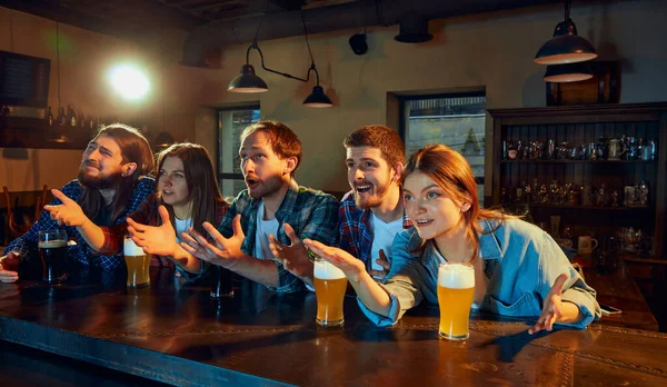朋友会议 年轻人 男人和女人在酒吧看比赛 粉丝们在感情上鼓舞着最喜爱的运动队 喝啤酒 锦标赛 比赛翻译 — 图库照片