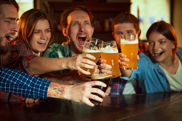 一群年轻人 男人和女人在酒吧看比赛 喝啤酒 粉丝们在感情上鼓舞着最喜爱的运动队 锦标赛 比赛翻译 — 图库照片