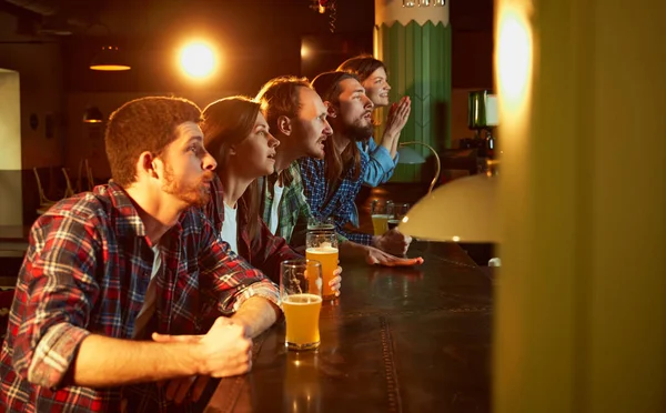 年轻人 男人和女人在酒吧观看比赛和喝啤酒 粉丝们在感情上鼓舞着最喜爱的运动队 赢的时刻 锦标赛 比赛翻译 — 图库照片