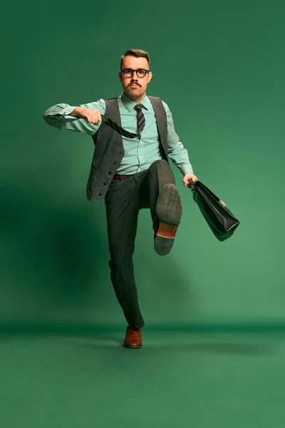 英俊男子的画像 身着古典西装 头戴绿色工作室背景公文包的商人 面部表情 时尚的概念 — 图库照片
