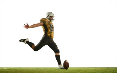 Kicking ball with leg. Man, american football player in uniform, in motion, training over white studio background. Concept of sport, movement, achievements, competition, hobby. Copy space for ad