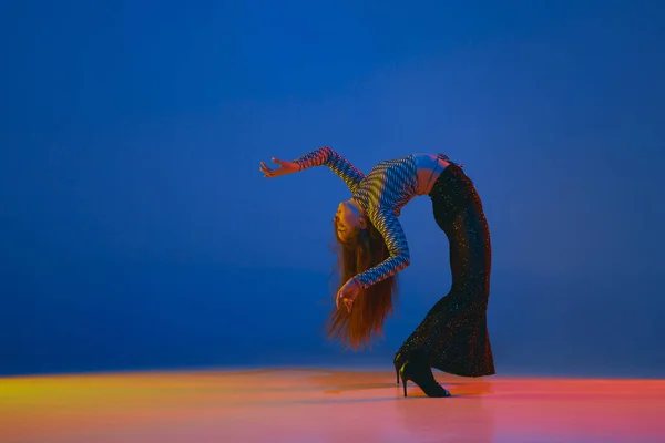 Гибкость Девушка Танцует Каблуках Стильной Одежде Синем Фоне Неоновом Свете — стоковое фото