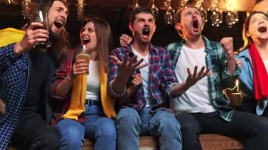 Group of emotive young people, men and women watching match at pub. Fans emotionally cheering up favourite sport team. Diverse of emotions. Competition, championship, match translation