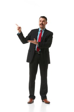Businessman in a suit pointing with finger at blank space for text over white studio background. Plan, presentation. Concept of business, career development, ambitions, strategy. Copy space for ad