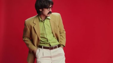 Man, businessman with moustache in vintage classic suit dancing, relaxing, greeting over red background. Concept of emotions, business, occupation, facial expression, fashion