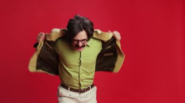 Man with mustache in vintage classic suit emotionally posing over red background. Attentively watching. Concept of emotions, business, occupation, facial expression, fashion. Retro style