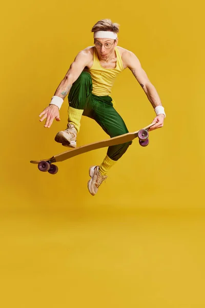 Portrait Young Cheerful Man Sports Uniform Jumping Skateboard Bright Yellow — Stockfoto
