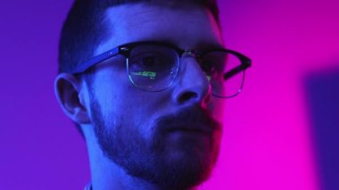 Coding. Businessman, programmer working on new online project, writing website, working on laptop online on gradient purple background in neon light. Concept of modern technologies, IT, business