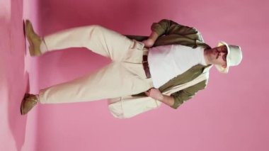 Relaxed stylish man with moustache in casual comfortable clothes dancing, having fun over pink studio background. Funny face. Concept of emotions, lifestyle, mens fashion, mood. Ad