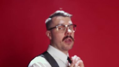 Burning deadlines, challenges. Emotional businessman in official classic suit posing, emotionally talking over red background. Concept of emotions, business, occupation, facial expression, fashion