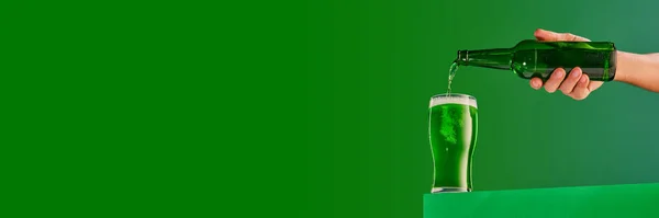 Male Hand Pouring Green Foamy Frosty Beer Glass Green Background — Stockfoto