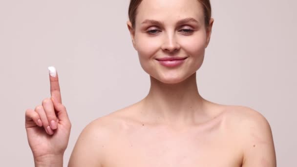 Hermosa Cara Femenina Clara Mujer Joven Aplicando Crema Facial Hidratante — Vídeos de Stock