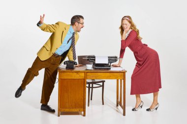 Stressful time. Quarrel. Businessman shouting at woman, personal assistant over grey background. Concept of business, professional relationship, communication, teamwork, occupation. Retro business