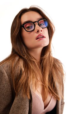 Portrait of young beautiful woman in stylish clothes and trendy sunglasses posing against white studio background. Concept of natural beauty, youth, health, wellness, femininity, make-up, fashion