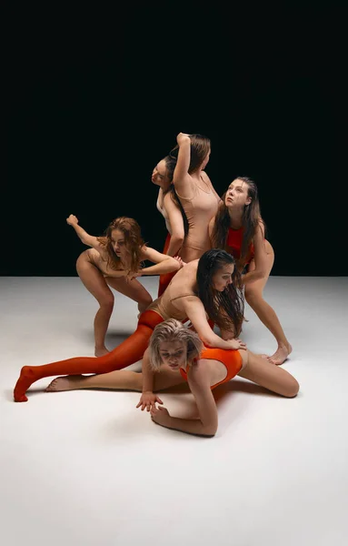 Flow of feelings. Young girls in bodysuits, contemporary, experimental dancers over black background. Concept of art of movement, youth, fashion, artistic lifestyle, flexibility, inspiration
