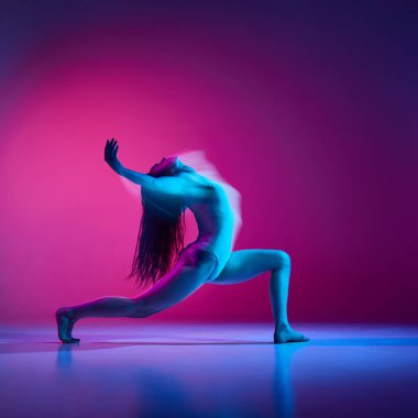Young flexible woman in bodysuit dancing over gradient pink studio background in neon with mixed lights. Concept of contemporary dance style, art, aesthetics, hobby, creative lifestyle