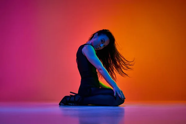 表現力豊かなダンス 若い女性は ネオンでグラデーションピンクオレンジ色のスタジオの背景の上で実行するダンサーへ コンテンポラリーダンススタイル アート 創造的なライフスタイルの概念 — ストック写真