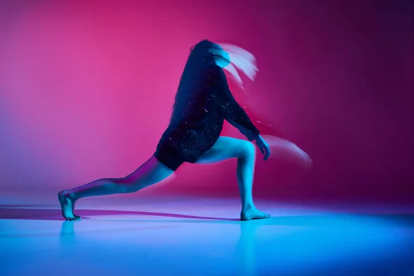 ネオンのグラデーションピンクのスタジオを背景に 光が入り混じった若い女性がコンテンポラリーダンスを踊る コンテンポラリーダンススタイル アート 創造的なライフスタイル 柔軟性の概念 — ストック写真