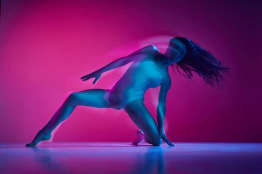 Freestyle. Sensuality. Young woman dancing in bodysuit over gradient pink studio background in neon with mixed lights. Concept of contemporary dance style, art, aesthetics, hobby, creative lifestyle