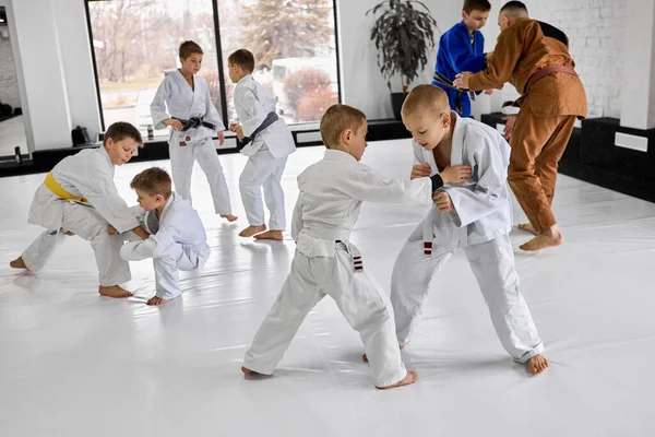 小男孩们 穿着白色和服的孩子们一起训练柔道 在室内和职业教练一起做柔道运动 武术概念 格斗运动 体育教育 — 图库照片