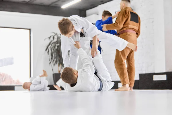 プロスポーツの練習 男の子 白い着物の子供たちは 屋内で柔道 柔術の練習を練習します 武道の概念 戦闘スポーツ スポーツ教育 子供の頃 — ストック写真