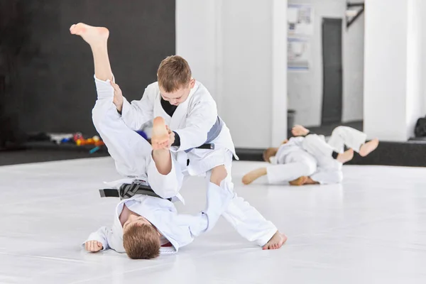 男の子 白い着物の子供たちは 屋内で柔道 柔術の練習を練習します 武道の概念 戦闘スポーツ スポーツ教育 小児期 — ストック写真
