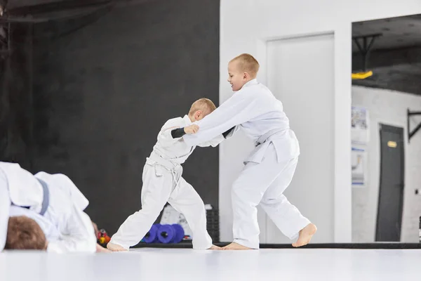 防御だ 男の子 白い着物の子供たちは 屋内で柔道 柔術の練習を練習します プロスポーツ選手 武道の概念 戦闘スポーツ スポーツ教育 子供時代 — ストック写真