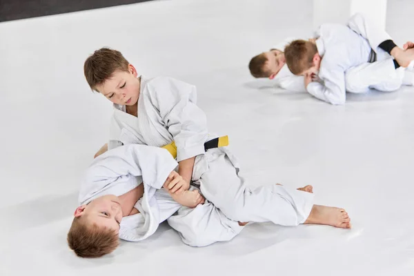 男の子 白い着物の子供たちは 屋内で柔道 柔術の練習を練習します 競争だ 武道の概念 戦闘スポーツ スポーツ教育 子供時代 — ストック写真