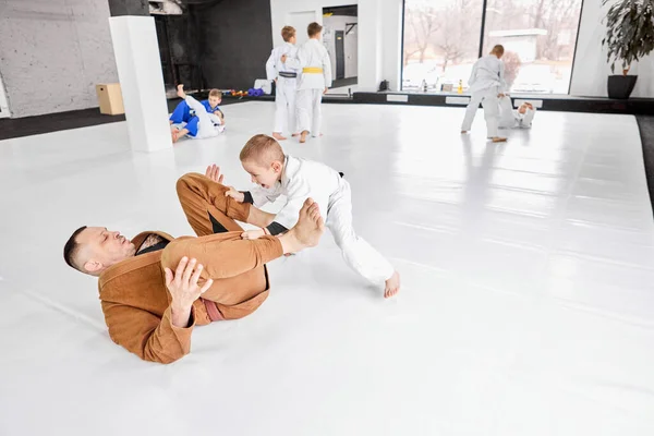 男人的动态肖像 职业柔道 柔道教练和小男孩一起训练 穿着白色和服的孩子 活泼的生活方式 武术概念 格斗运动 体育教育 — 图库照片