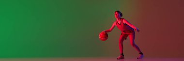Teen girl, basketball player isolated over gradient green red background in neon light. Concept of sportive lifestyle, active hobby, health, competition. Banner. Copy space for ad, text