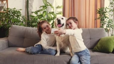 İki küçük kız, güzel bir köpekle özçekim yapan kız kardeşler, golden retriever. Akıllı evcil hayvan ve ilgili çocuklar. Aile kavramı, çocukluk, evcil hayvanlar, bakım, arkadaşlık, duygular. Boş zaman