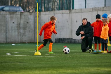 Boys, children in uniform playing, training football with professional coach on sports field outdoors. Competition. Concept of sport, childhood, active lifestyle, hobby, sport club