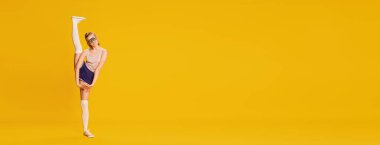 Standing on twine, stretching. Full-length image of beautiful slim young girl training over yellow studio background. Concept of beauty, sportive lifestyle, hobby, emotions. Banner. Copy space for ad