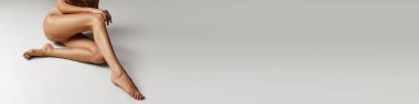 Cropped image of smooth tanned slim female legs over grey studio background. Depilation, epilation, laser hair removal. Concept of body and skin care, fitness, health Banner, flyer. Copy space for ad