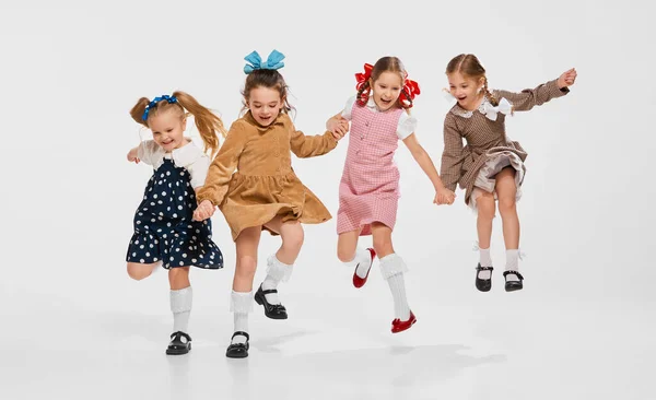 Cztery Piękne Dziewczynki Dzieci Stylowych Sukienkach Retro Skaczące Szarym Tle — Zdjęcie stockowe