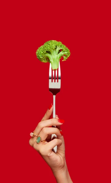 Mano Femenina Sosteniendo Brócoli Sobre Tenedor Sobre Fondo Rojo Estudio — Foto de Stock