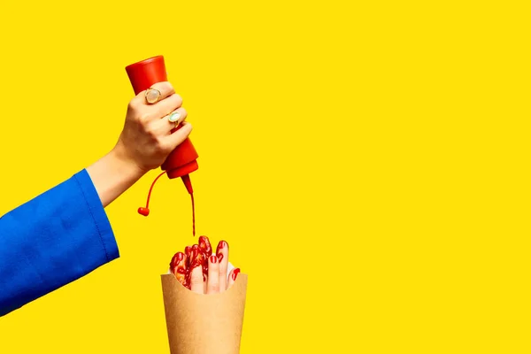 Ketchup Gießen Weibliche Finger Statt Pommes Verpackungen Vor Gelbem Studiohintergrund — Stockfoto