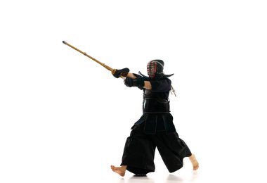 Profesyonel kendo sporcusu, üniformalı, bambu kılıçlı beyaz atölyeye karşı shinai. Dövüş sanatları, spor, Japon kültürü, aksiyon ve hareket kavramı