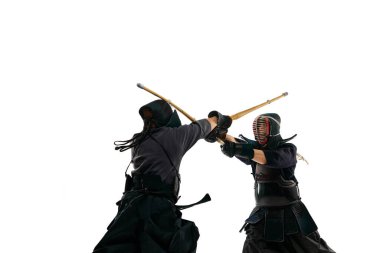 İki adam, profesyonel kendo atletleri özel üniforma eğitimi alıyorlar, beyaz stüdyo geçmişine karşı shinai kılıçla dövüşüyorlar. Dövüş sanatları, spor, Japon kültürü, aksiyon ve hareket kavramı