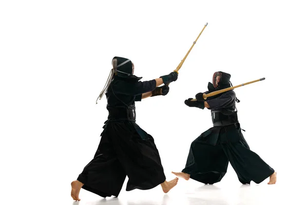 2人の男性 運動中のプロの剣道選手 白のスタジオの背景に竹の剣で訓練 スポーツ 日本文化 アクションの概念 — ストック写真
