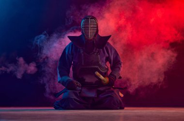 Dostum, profesyonel kendo atleti, Shinai kılıcıyla neon ışıkta dumanlı karanlık arka planda poz veren savaşçı. Dövüş sanatları, spor, Japon kültürü, aksiyon ve