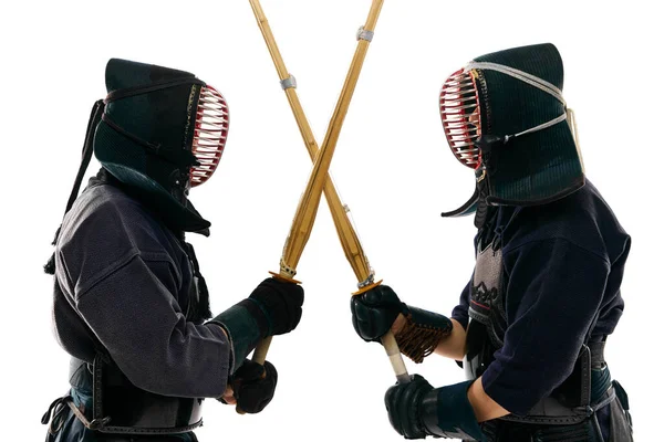 プロの剣道選手 黒のユニフォームの選手 白のスタジオの背景に剣を横断する2人の男性 スポーツ 日本文化 アクション 動きの概念 — ストック写真