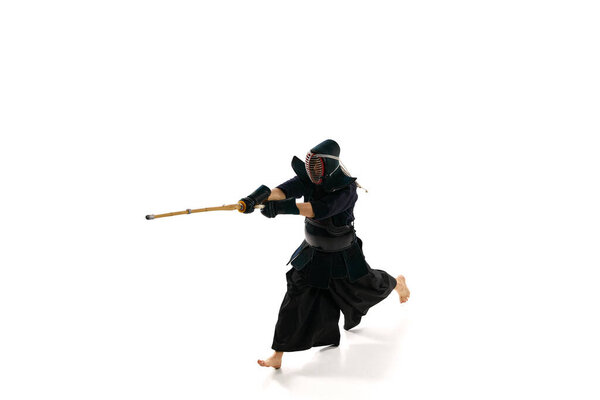 Вид сверху. Мужик, профессиональный кендо спортсмен в форме с тренировкой шлема с бамбуковым мечом синай на белом фоне студии. Концепция боевых искусств, спорта, японской культуры, действия и движения